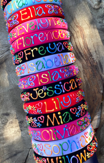 Colourful hand painted personalised hairbands, headbands with popular girls' names including Isla, Sophia and Olivia.